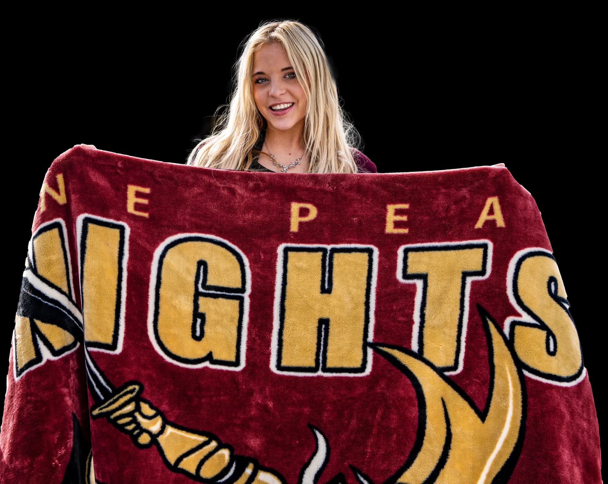 A finished custom printed keepsake blanket, the maroon and gold Nepean Knights design, held up at a stadium